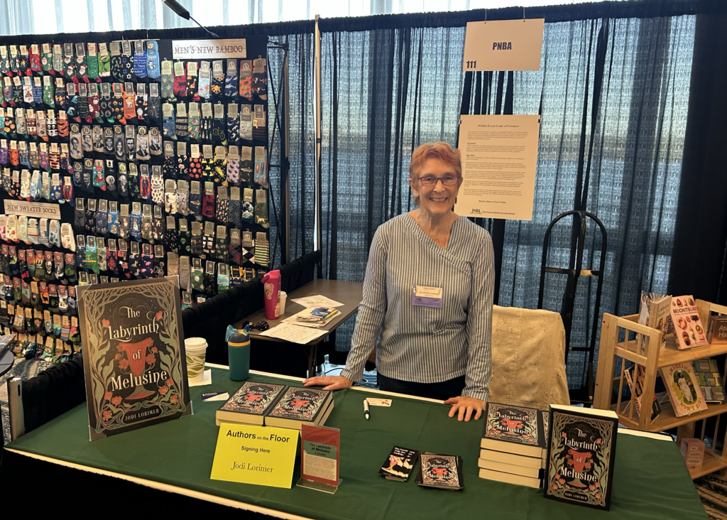 Author Jodi Lorimer at a table displaying her books